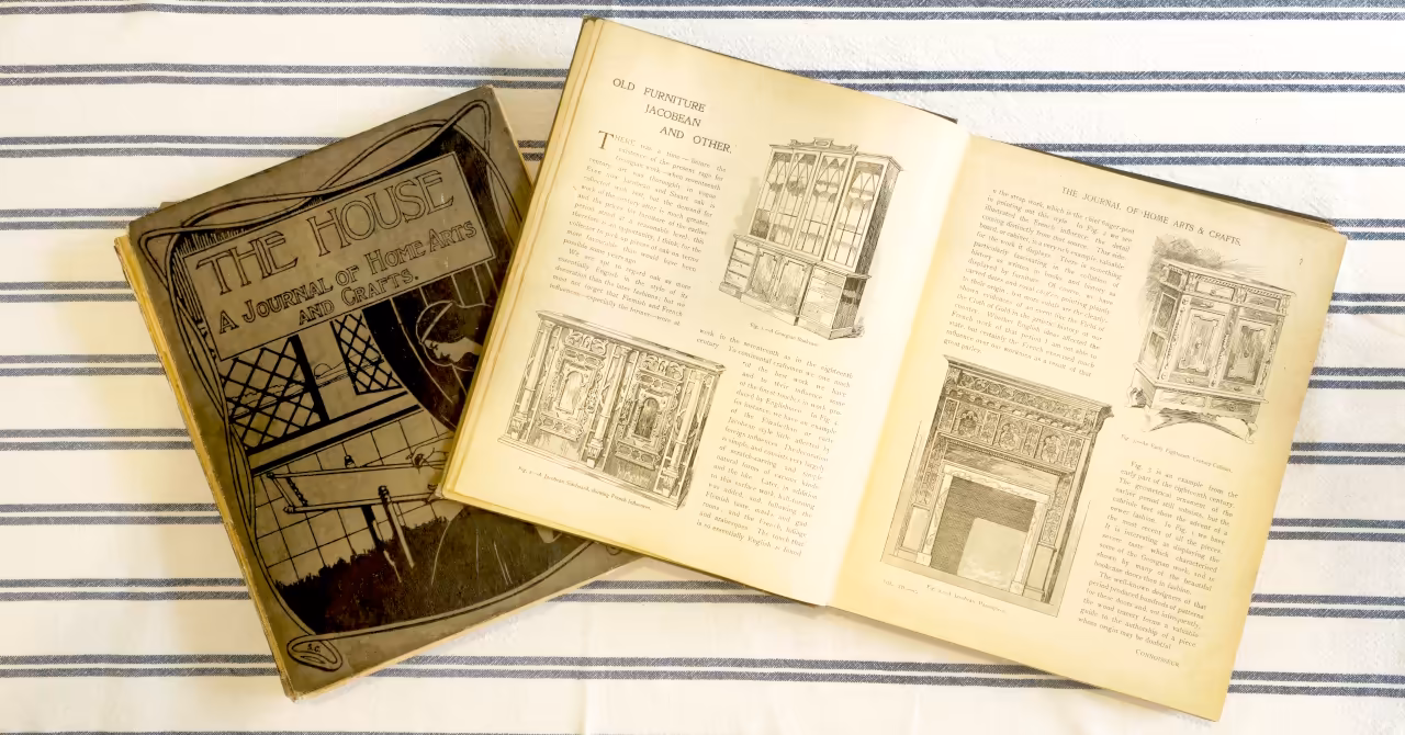 Photopraphs of two volumes of The House journal, one open, displayed on a dining table.